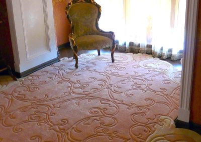 Sculpted wool rug flowing into a bay window area