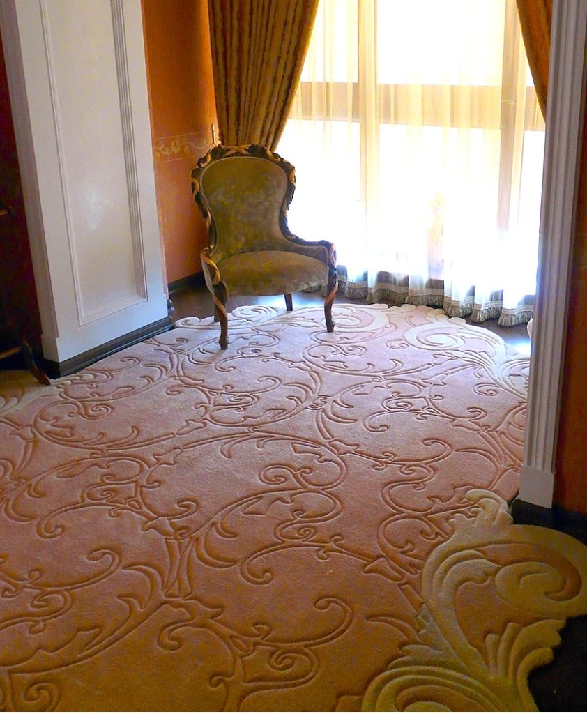 Sculpted wool rug flowing into a bay window area