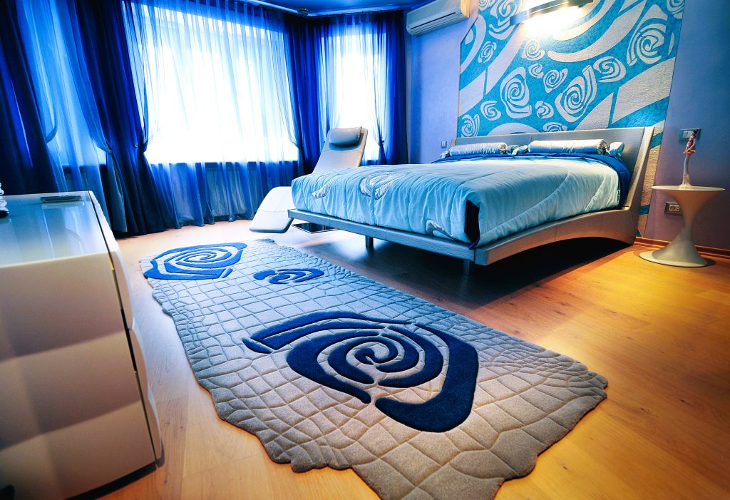 Grey blue rug with pattern and texture in bedroom interior